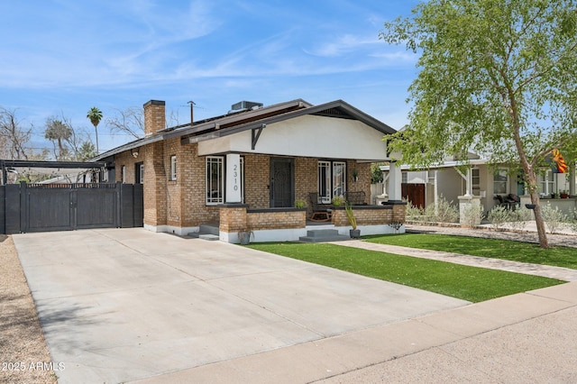 2310 N 11th St, Phoenix, AZ 85006 - view of front of home with a gate, brick siding, covered porch, a chimney, and driveway