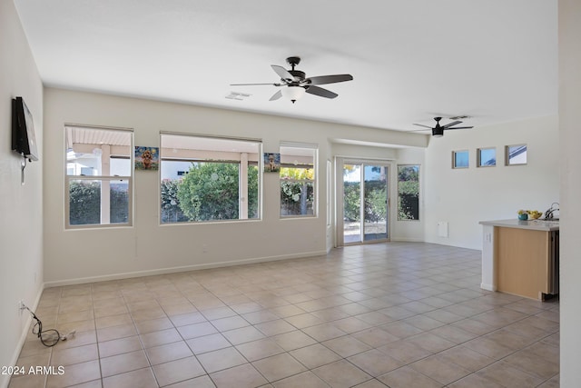 unfurnished room featuring a wealth of natural light, light tile patterned floors, and ceiling fan