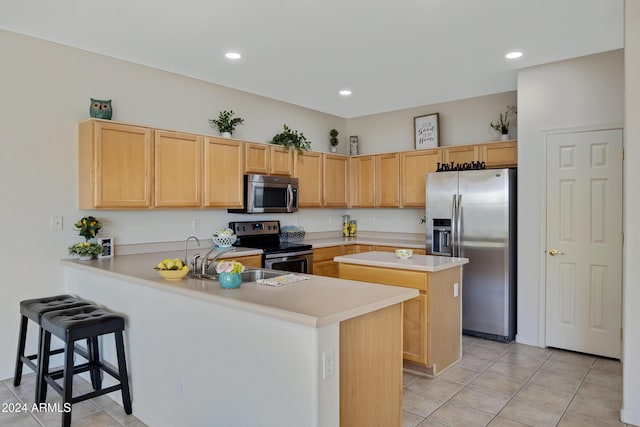 kitchen with a breakfast bar, light brown cabinets, light tile patterned flooring, kitchen peninsula, and stainless steel appliances