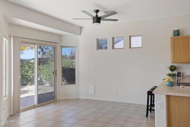 unfurnished dining area featuring ceiling fan, light tile patterned flooring, and sink