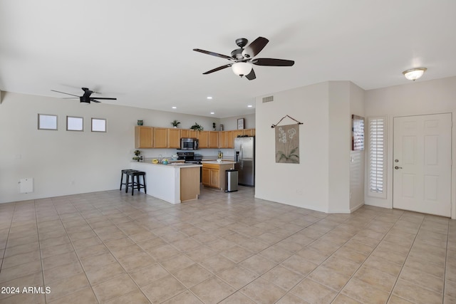 kitchen featuring kitchen peninsula, stainless steel appliances, ceiling fan, and light tile patterned flooring