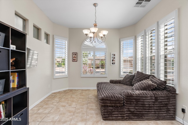 living area featuring a chandelier, tile patterned floors, and baseboards