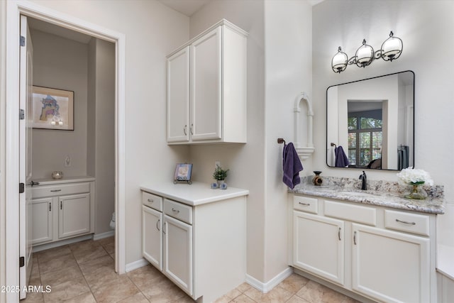 bathroom featuring vanity, baseboards, and toilet