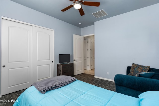 bedroom with wood tiled floors, a closet, baseboards, and a ceiling fan