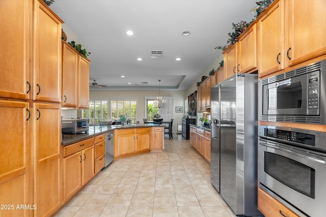 kitchen with stainless steel appliances, a peninsula, recessed lighting, light tile patterned flooring, and a ceiling fan