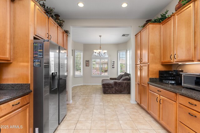 kitchen with stainless steel refrigerator with ice dispenser, light tile patterned floors, recessed lighting, a chandelier, and baseboards