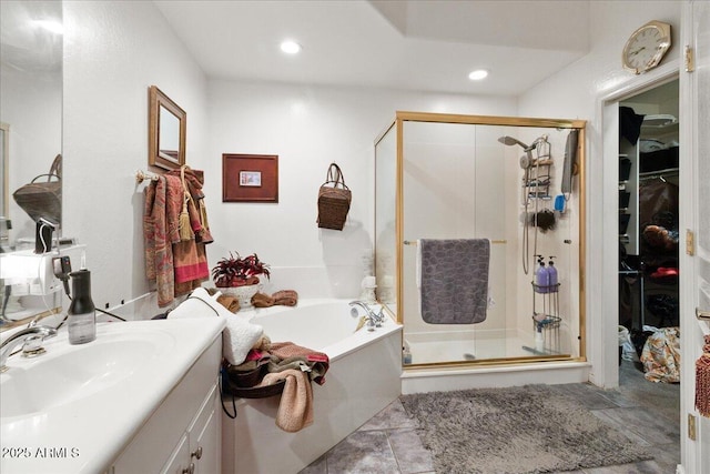 full bathroom featuring vanity, a bath, a shower stall, a spacious closet, and recessed lighting