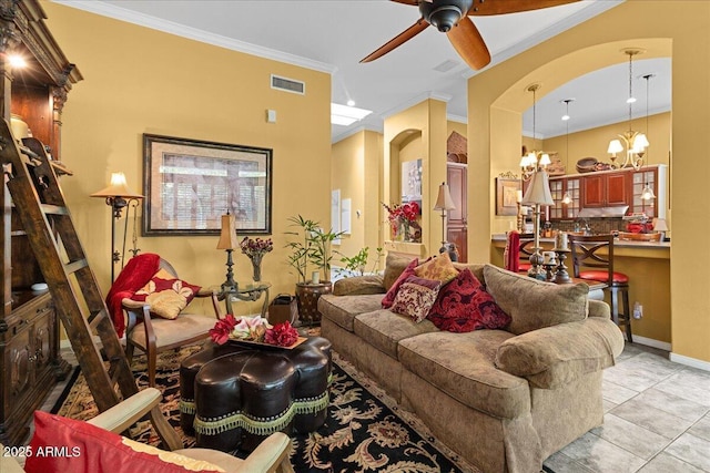 living area with a chandelier, a ceiling fan, crown molding, arched walkways, and light tile patterned floors