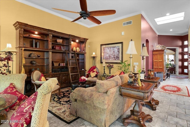 living area featuring ceiling fan, ornamental molding, a skylight, and recessed lighting