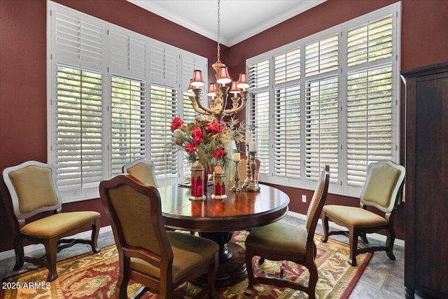 dining space featuring a chandelier, crown molding, and baseboards