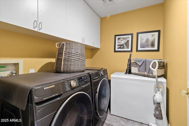laundry room with cabinet space, washing machine and clothes dryer, and light tile patterned flooring