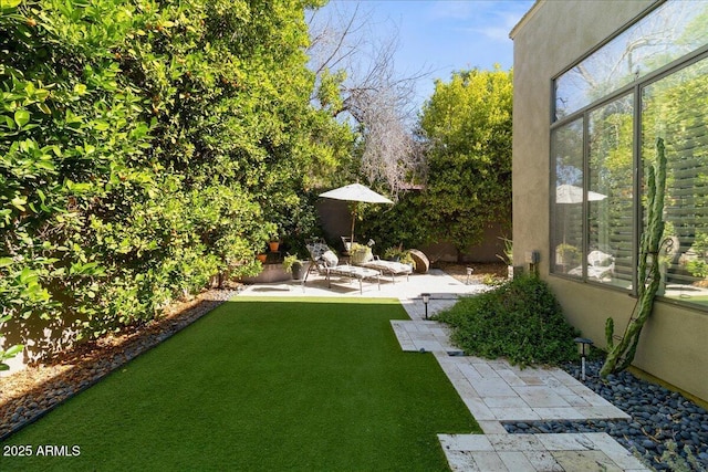 view of green lawn featuring a patio