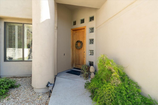 doorway to property featuring stucco siding
