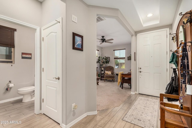 foyer featuring ceiling fan, baseboards, and light wood finished floors
