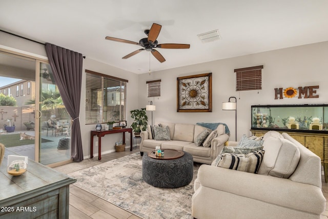 living room with a ceiling fan, light wood-type flooring, and visible vents