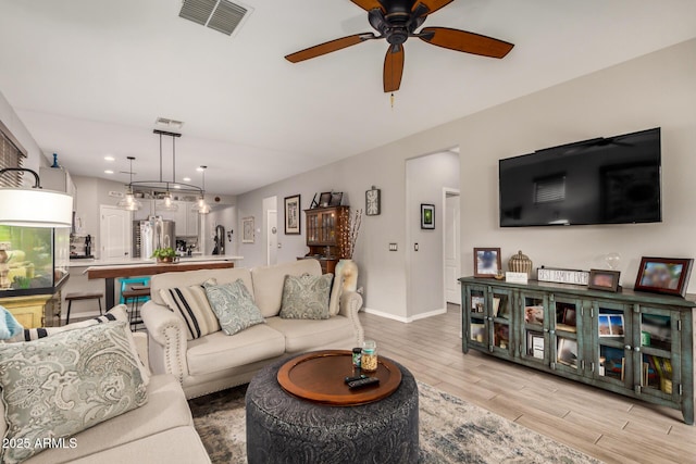 living area with ceiling fan, light wood-style flooring, recessed lighting, baseboards, and visible vents