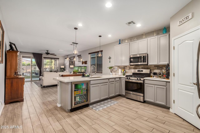 kitchen with visible vents, appliances with stainless steel finishes, gray cabinetry, beverage cooler, and open floor plan