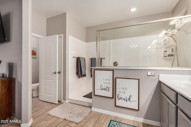 full bath featuring vanity, baseboards, toilet, and wood finished floors
