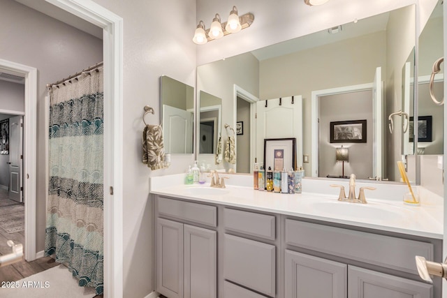 full bathroom with visible vents, a sink, and double vanity