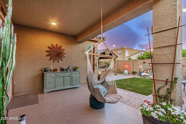 patio terrace at dusk with a fenced backyard
