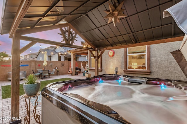 view of patio / terrace featuring fence, outdoor dining space, a gazebo, a hot tub, and a ceiling fan