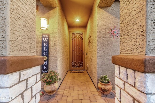 view of exterior entry with stucco siding