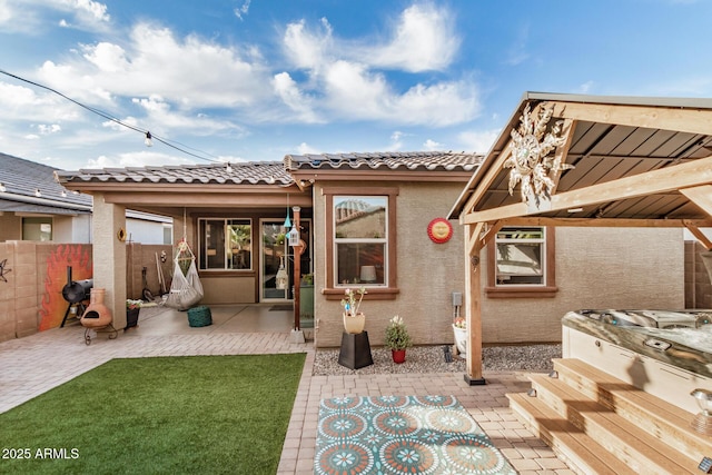back of house featuring fence, a tile roof, a patio area, and stucco siding