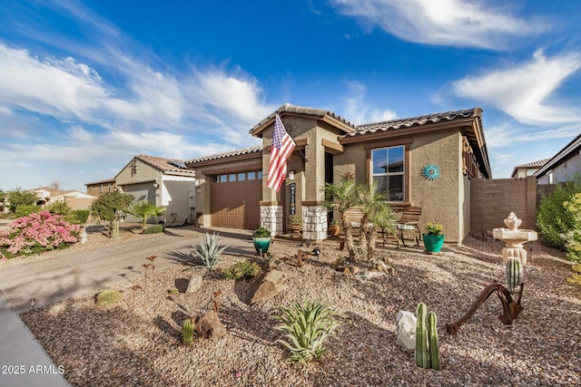 view of front facade with a garage, fence, stucco siding, a tiled roof, and driveway