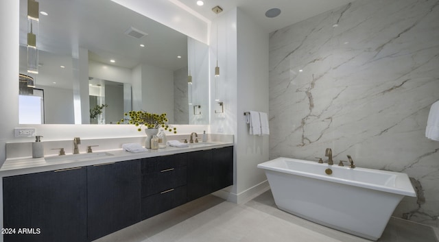 bathroom featuring tile walls, dual sinks, tile flooring, large vanity, and a tub