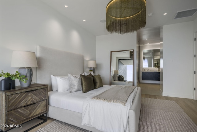 bedroom featuring wood-type flooring and connected bathroom