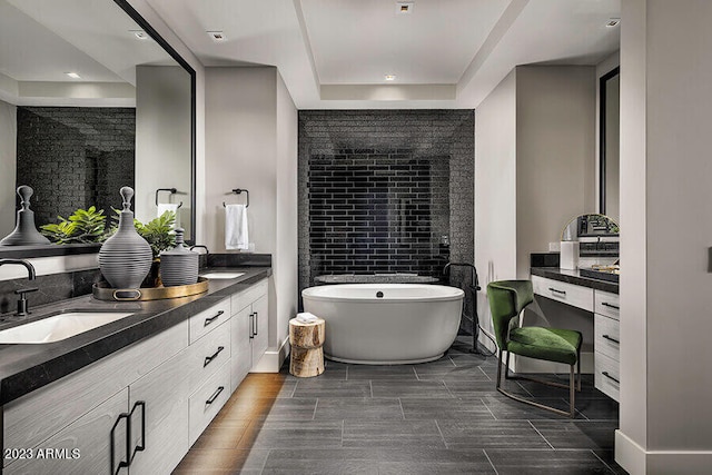 bathroom featuring tile floors, dual sinks, a raised ceiling, and vanity with extensive cabinet space