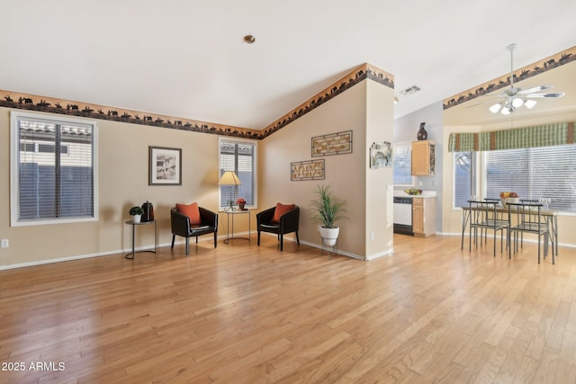 living area featuring ceiling fan, lofted ceiling, light hardwood / wood-style floors, and plenty of natural light