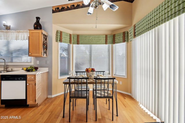 dining space featuring ceiling fan, a wealth of natural light, light hardwood / wood-style flooring, and vaulted ceiling