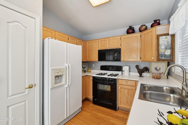 kitchen with light brown cabinetry, white refrigerator with ice dispenser, gas stove, and sink