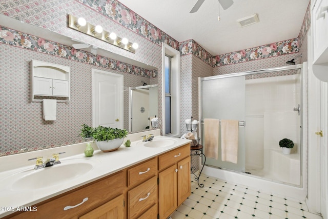 bathroom with walk in shower, vanity, and ceiling fan