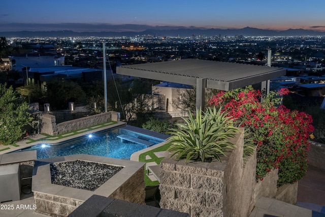 pool at dusk with a patio area, a mountain view, and an outdoor fire pit