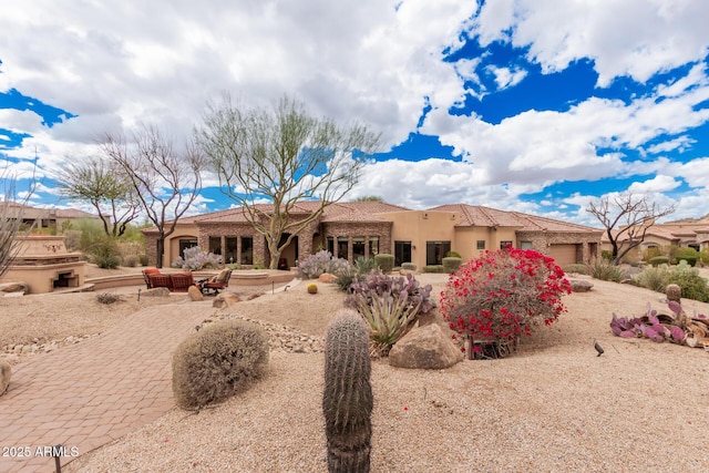 back of house featuring an attached garage, a patio area, and stucco siding