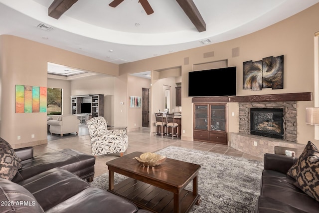 tiled living room featuring beam ceiling, visible vents, a fireplace, and a tray ceiling