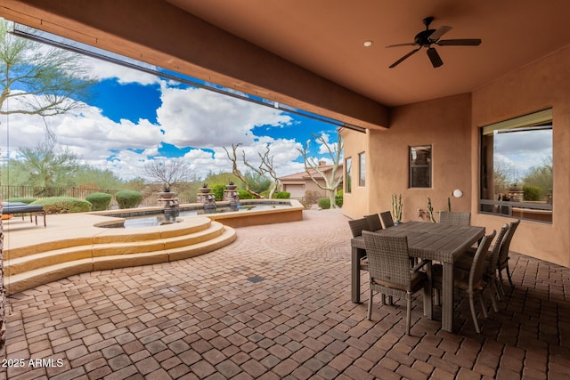 view of patio with outdoor dining area, a ceiling fan, and fence