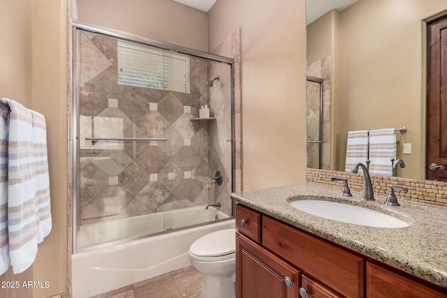 bathroom with combined bath / shower with glass door, toilet, and vanity