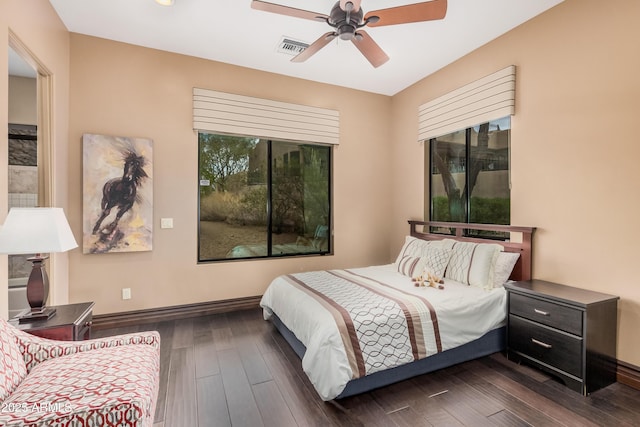 bedroom featuring ceiling fan, dark wood-style floors, visible vents, and baseboards