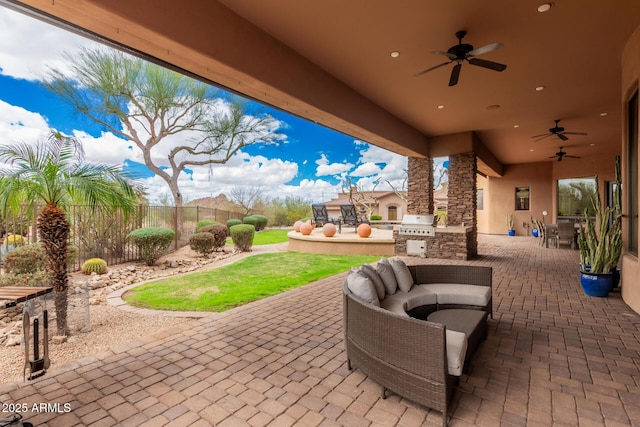 view of patio featuring a ceiling fan, fence, exterior kitchen, area for grilling, and an outdoor living space