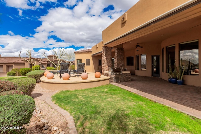 view of yard featuring a ceiling fan, area for grilling, and a patio area