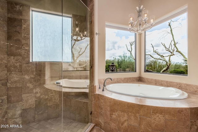 bathroom with a garden tub, a notable chandelier, a wealth of natural light, and tiled shower