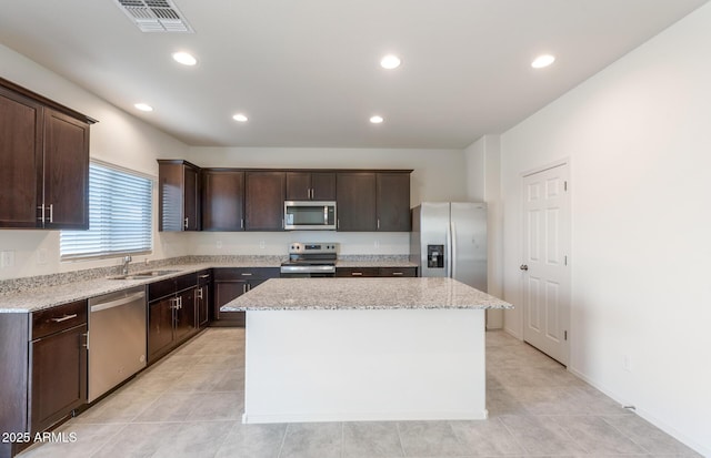 4993 S 254th Dr, Buckeye, AZ 85326 - kitchen with stainless steel appliances, a kitchen island, dark brown cabinetry, recessed lighting, and a sink