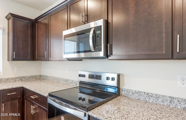 4993 S 254th Dr, Buckeye, AZ 85326 - kitchen with stainless steel appliances, dark brown cabinets, and light stone counters