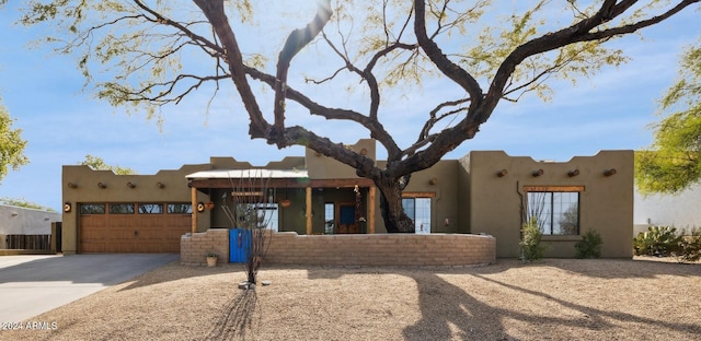 pueblo revival-style home featuring a garage