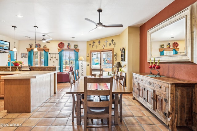 dining room featuring ceiling fan, sink, and light tile patterned flooring