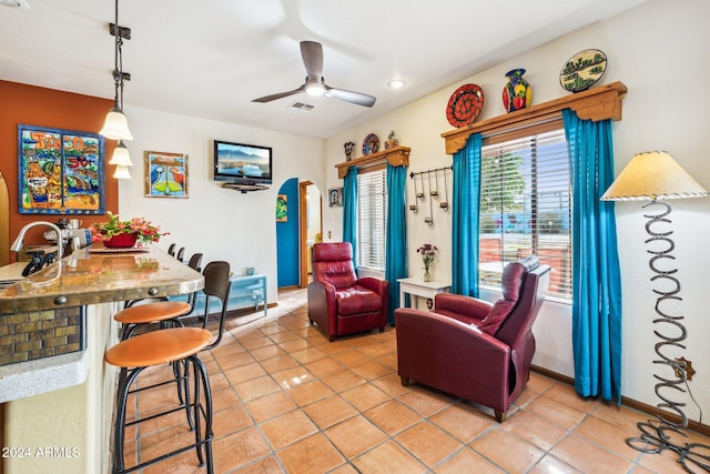 tiled living room featuring ceiling fan and sink