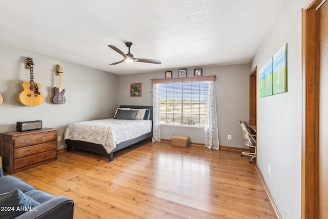 bedroom featuring ceiling fan, a textured ceiling, and light hardwood / wood-style flooring